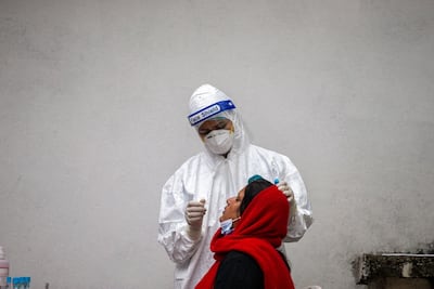 A health worker collects a nose swab sample for a PCR test. EPA