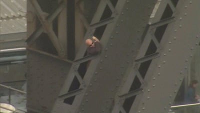 A man climbs the arch of the Sydney Harbour Bridge on Friday. Seven Network via Reuters