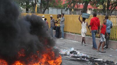 People walk past a burning barricade. Reuters