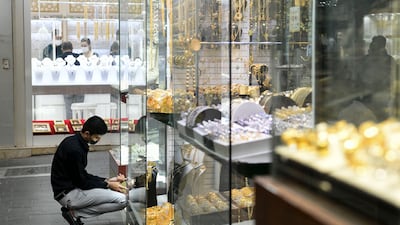 A staff member adds pieces to a window display at the gold souq. It is a popular attraction for visitors to Dubai.