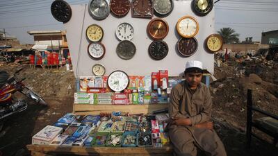 Vendor Muhammad Ahmad marks time with his wares, as does a young refugee at his dress shop in the city.