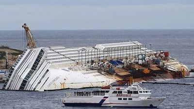 Relatives of victims stand on a ferry in front of the capsized cruise liner Costa Concordia outside Giglio harbour. Stefano Rellandini / Reuters