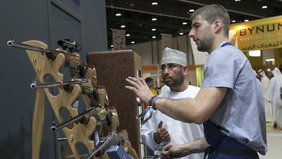 Olivier Leclercq explains to a visitor at Adihex in Abu Dhabi yesterday the different guns made by Rigby, the London-based gunsmiths. Mona Al Marzooqi / The National