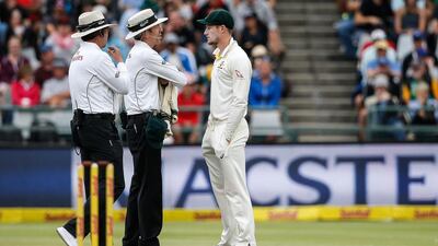 Australian fielder Cameron Bancroft, right, is questioned by umpires Richard Illingworth, left, and Nigel Llong, centre, during the third day of the third Test cricket match between South Africa and Australia at Newlands cricket ground in Cape Town. AFP/GIANLUIGI GUERCIA