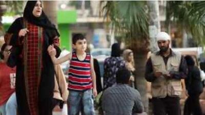 A beggar in Jordan, right, distributes verses of the Quran.