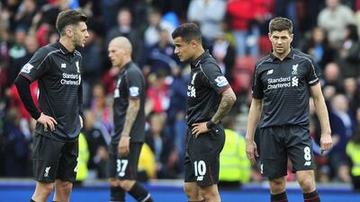 Liverpool's Adam Lallana, left, Philippe Coutinho and Steven Gerrard wait to kick off after conceding one of many goals against Stoke City at the Britannia Stadium on May 24, 2015. It was Gerrard's final Premier League match. AFP PHOTO / STEVE PARKIN