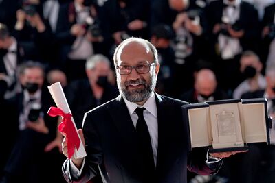 Iranian director Asghar Farhadi with his trophy after he was awarded the Grand Prix for his film 'A Hero' at the Cannes Film Festival. AFP