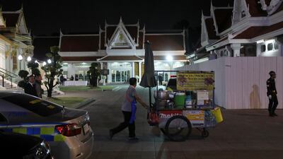 A street vendor passes by the temple during the funeral. Reuters