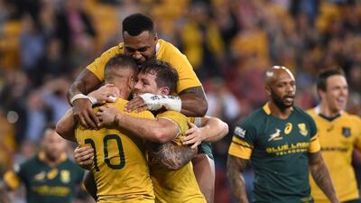 Australia's Bernard Foley, centre, celebrates after scoring a try during the Rugby Championship match between the Australian Wallabies and the South African Springboks. Dave Hunt / EPA