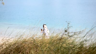 A man walks along the Corniche, Abu Dhabi. Khushnum Bhandari / The National