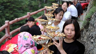 Staff serve food to the guests in attendance. AFP