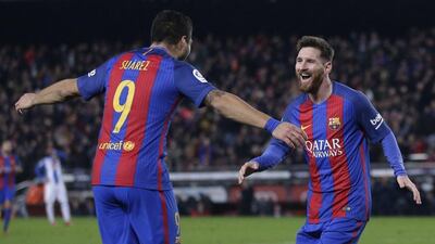 Lionel Messi, right, celebrates with Luis Suarez after scoring against Espanyol. Manu Fernandez / AP Photo