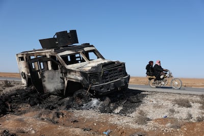 Men on a motorbike pass a destroyed Syrian Democratic Forces (SDF) vehicle in Al Hasakah. Getty Images