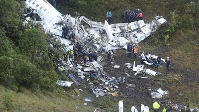 Rescue workers carry a body away from the wreckage of the chartered aeroplane was carrying the Brazilian football team Chapecoense. Luis Benavides / AP Photo