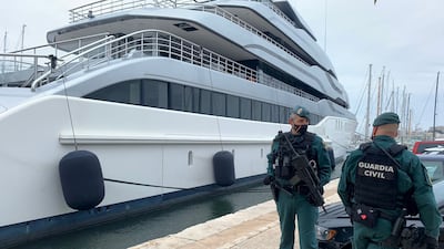 Spanish Civil Guards stand by the Tango superyacht, belonging to Russian oligarch Viktor Vekselberg, which was seized on behalf of US authorities. Photo: Juan Poyates Oliver / Reuters