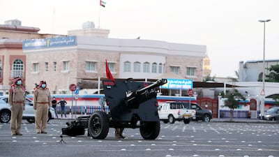 Dubai Police officers in 2020 prepare to fire a cannon in Al Mankhool area of Dubai. Pawan Singh / The National