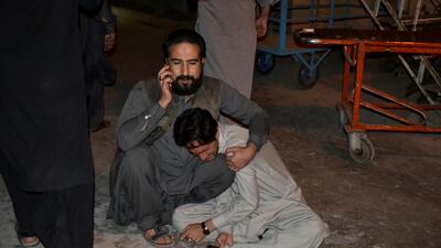 A man comforts another who mourns the death of a relative after an explosion at a luxury hotel, at a hospital in Quetta, Pakistan. Reuters