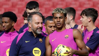 Barcelona's Lamine Yamal with head coach Hansi Flick during the team's first training session at the Camp Nou. AP