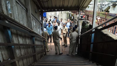 Indian security personnel and media gather at the scene of a stampede on a railway bridge in Mumbai. AFP