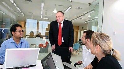 Nick van der Walt, the executive director of Hult's campus in Dubai, centre, with the students. Pawan Singh / The National