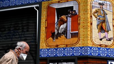 An elderly man,, wearing a face mask, walks past a closed restaurant in Madrid, during the hours allowed by the government to exercise, for the first time since the beginning of a national lockdown to prevent the spread of the Covid-19 disease. AFP