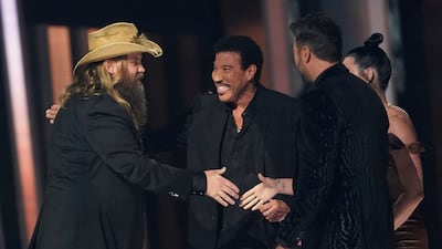 Chris Stapleton, left, accepts the Song of the Year award for 'Starting Over' from presenters Lionel Richie, centre, and Luke Bryan. AP