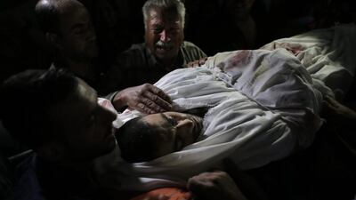A Palestinian relative mourns over the body of Ahmed Al-Serhi, 27, who was killed during clashes with Israeli troops near the Israeli border with Gaza, during his funeral at the family house in Deir el-Balah, in the central Gaza Strip. Khalil Hamra / AP Photo