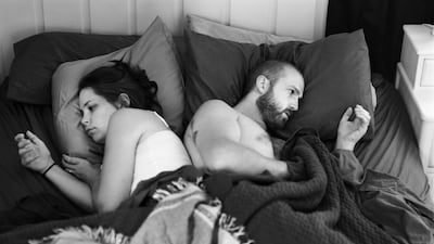 Pickersgill in bed with his wife, his back to hers. Both are intently focused on where their phones are supposed to be. Their hands cupped awkwardly. Pickersgill says he used a remote control to take the picture. “If you look closely at the photograph, you’ll see my right hand covered by the bedsheets,” he says. Courtesy Eric Pickersgill