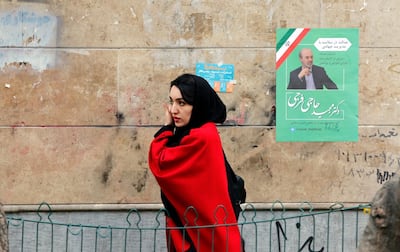 An Iranian woman walks past an electoral billboard in a street of Tehran. EPA
