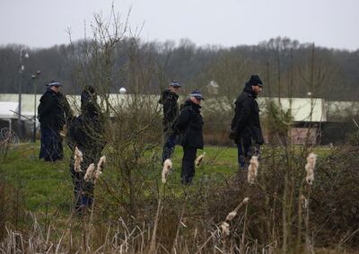 Officers from the Metropolitan Police search a field in Ashford, England. AP.