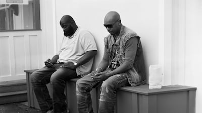 Two men sit beside each other, more interested with the phones that should be in their hands than each other. Pickersgill's Removed shows us just how much we are enveloped by the contents of our screens. Courtesy Eric Pickersgill