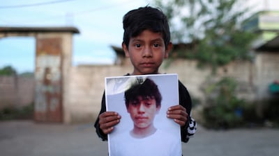 Alfonso holds a picture of 13-year-old Pascual Melvin Guachiac who died in a tractor-trailer along with other migrants in San Antonio, Texas, in a village in Nahuala, Guatemala, on June 29. Reuters