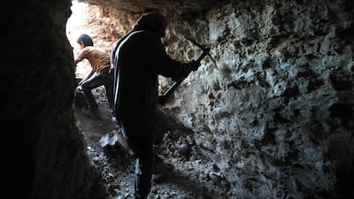 A man uses a pickaxe to dig a cave in the Syrian village of Kafr Ain in the southern countryside of the rebel-held Idlib province on September 15, 2018. AFP