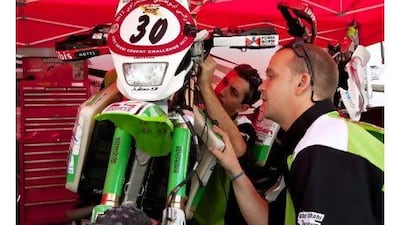 Desert Frog Racing mechanics fine-tune the team's motorcycle at Yas Marina yesterday in preparation for the 2,000 kilometre desert challenge. Christopher Pike / The National