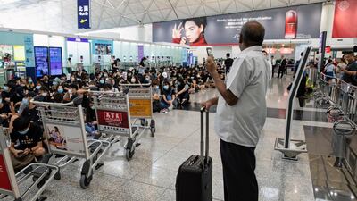 A passenger stands with his luggage as demonstrators block a departure hall during the protest at the Hong Kong International Airport. Bloomberg