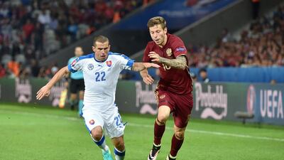 Slovakia’s midfielder Viktor Pecovsky (L) vies for the ball with Russia’s forward Fedor Smolov during the Euro 2016 group B football match between Russia and Slovakia at the Pierre-Mauroy Stadium in Villeneuve-d’Ascq, near Lille, on June 15, 2016. / AFP / PHILIPPE HUGUEN