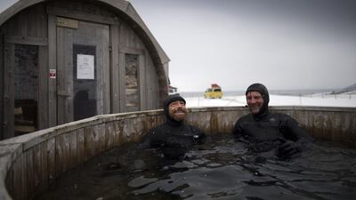 Australian surf legend Tom Carroll, 55, and Norwegian surfer Tommy Olsen keep warm in a hot bath after surfing the Arctic waves.