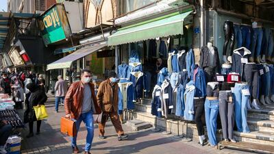 Iranians wearing protective masks amid the COVID-19 pandemic, walk on a market street in the capital Tehran. AFP