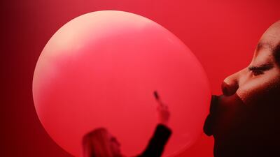A woman holds up an electronic device during the GSMA's 2023 Mobile World Congress in Barcelona, Spain. Reuters