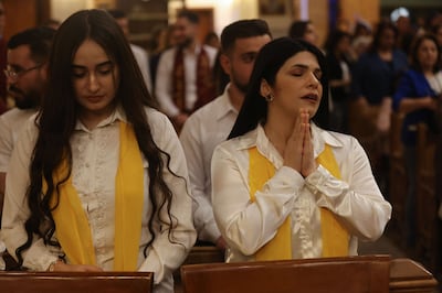 Christians in Baghdad pray during a service at the Coptic Orthodox Patriarchate Church mass for world peace, where all denominations gathered to pray for an end to the war in the Middle East on April 16, 2026. AFP