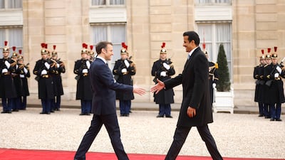 Mr Macron and Sheikh Tamim shake hands. EPA