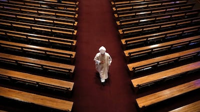 Bishop William Joensen proceeds down the main aisle at the conclusion of Holy Thursday Mass in a near empty St. Ambrose Cathedral, in Des Moines, Iowa. AP