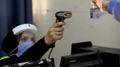 An electoral worker checks the ID card of a person during parliamentary elections. Reuters