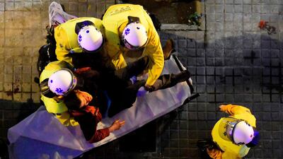 Paramedics carry an injured protester following clashes between protesters and riot police blocking the road leading to the central government offices during a demonstration in Barcelona, Spain, on March 25, 2018 after Catalonia's former president was arrested by German police. Lluis Gene / AFP Photo