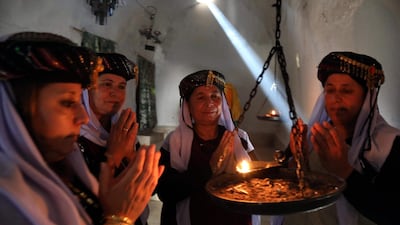 Iraqi Yazidi women pray at the Temple of Lalish, in a valley near the Kurdish city of Dohuk about 430km northwest of the capital Baghdad, on July 16, 2019. AFP