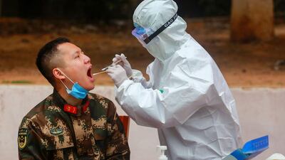Medical staff members collect samples from Chinese paramilitary police officers as he returns from holidays in Shenzhen in China's southern Guangdong province. AFP