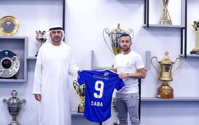 Israeli midfielder Dia Saba posing with a club official after signing for Al Nasr. AFP