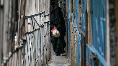 A Palestinian woman heads back to her family having bought bread from a bakery in Gaza city. AP