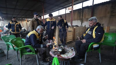 Members of the White Helmets keeping warm in Maaret al-Numan in Syria's southern Idlib governorate. AFP
