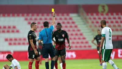 Al Ahli’s Asamoah Gyan receives a yellow card after fouling Emirates’ Haitham Ali, ground, during their Arabian Gulf League match in Dubai on Saturday. Christopher Pike / The National